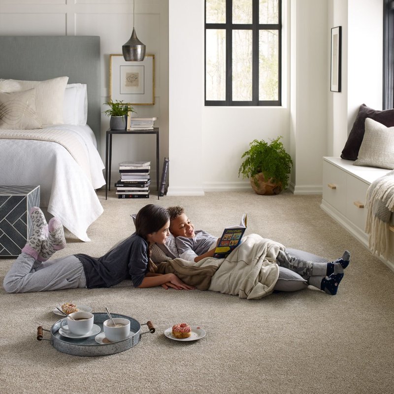 people reading a book laying on the floor from Wilkins Carpet and Tile Center in Taylors